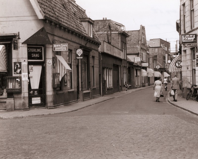 Willemstraat in westelijke richting (Kalanderstraat) met o.a. slagerij P.L. van Lier en sigarenmagazijn mei 1955.jpg