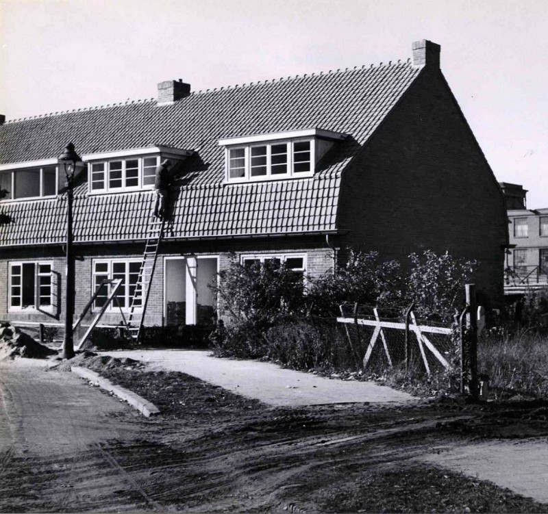 Borneostraat gezien vanaf de Beltstraat met woningen van woningbouwvereniging Ons Huis en daarachter textielfabriek J.F. Scholten & Zn. 1945.jpg