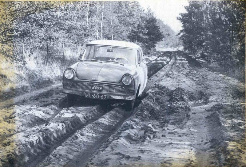 Hagmolenbeekweg 6-2-1964 De oude audi is leeg, er zitten diepe wielsporen in de zandweg, en rondom een bosachtige omgeving.jpg