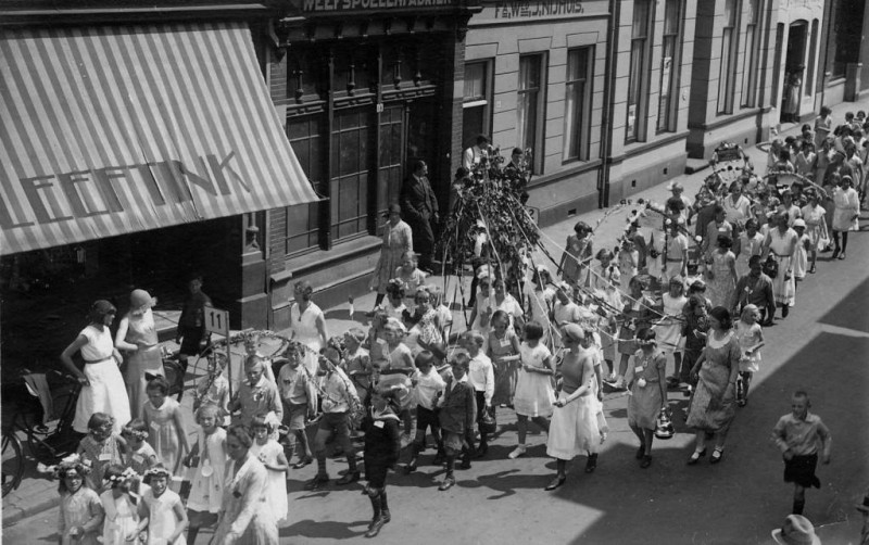 Oldenzaalsestraat 1930 gedeelte tussen Hoge Bothofstraat en de Van Lochemstraat, optocht Pinksterbruidje. panden Leeftink en Fa. Wed. J. Nijhuis.jpg