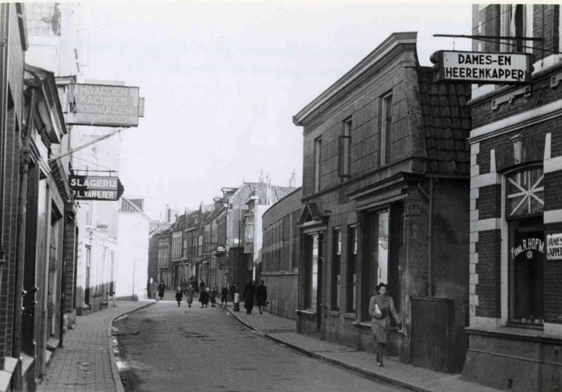 Kalanderstraat in noordelijke richting vanaf kapper Hofman en slager Van Lier.rechts de laagbouw de kalanderij van Menko. feb. 1944.jpg