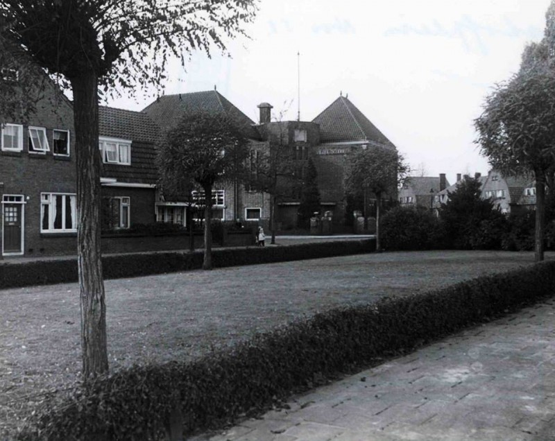 Elshofplein vooraan grasveld met op achtergrond vierde school met de Bijbel.1951.jpg