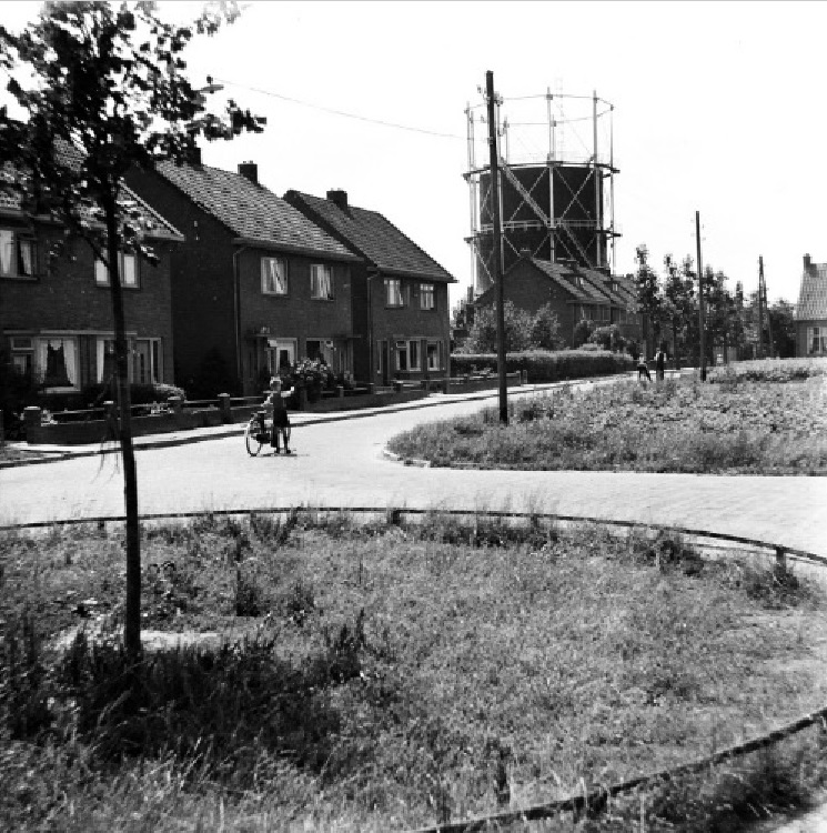 met fiets bij huizen op de achtergrond gashouder in de gaskrim.jpg