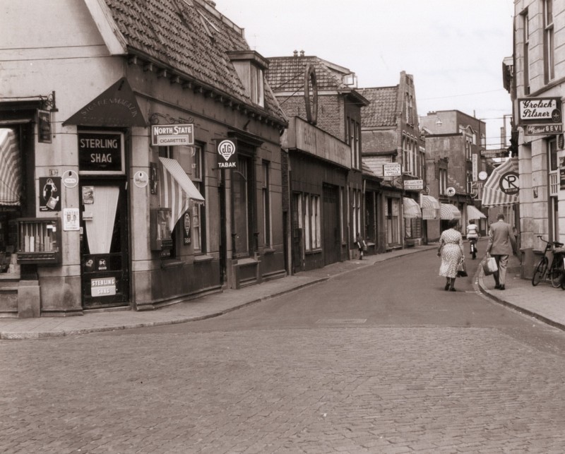Willemstraat in westelijke richting (Kalanderstraat) met slagerij P.L. van Lier en sigarenmagazijn mei 1955. rechts Gevi.jpg