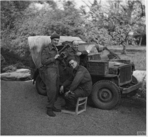 AFPU personnel, Dick Gee, 'Tubby' Palmer and Sergeant Eddy Smales posing in front of the unit Jeep at Enschede, Netherlands, May 1945..JPG
