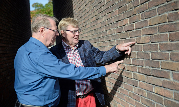 Broers Henny (links) en Harry Haverkort bij hun oude woning aan de Boeroestraat. In een zijmuur staan nog steeds de initialen die zij met hun vriendengroep in de stenen krasten. © Annina Romita.jpg