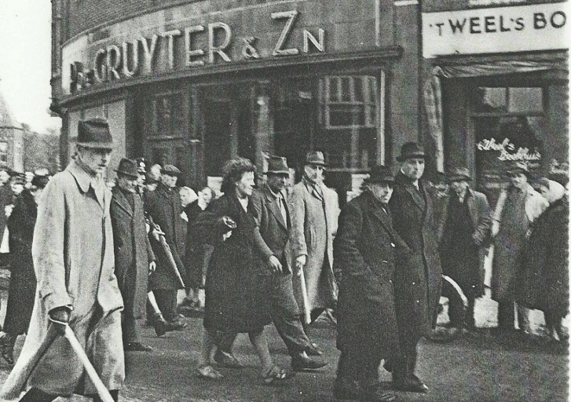 Haaksbergerstraat 45 't Weel's Boekhuis hoek C.F. Klaarstraat 2 De Gruyter.NSB'ers worden opgebracht 1-4-1945.jpg