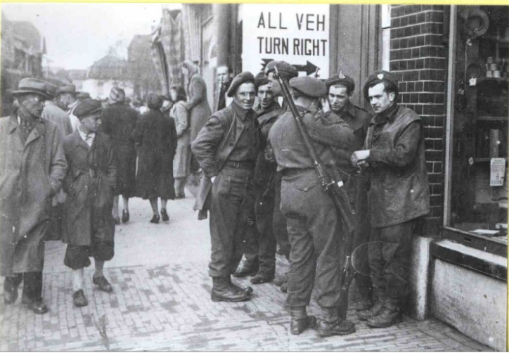 Haaksbergerstraat. Groepje soldaten (bevrijders) staat te overleggen, passanten kijken toe. april 1945.jpg