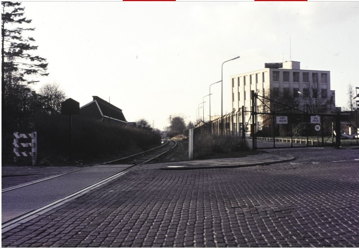 Volksparksingel 21 Spoorlijn Boekelo-Enschede-Ahaus in westelijke richting ter hoogte van de Borstelweg met rechts de ingang van Textielfabriek Holland. Later wordt hier de Westerval aangelegd 26-1-1975.jpg