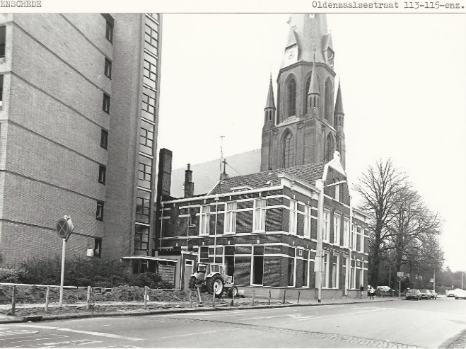 Oldenzaalsestraat 109-113-115 in de richting van de Lasonder- en Laaressingel, met aan de linkerkant de Cityflat, pastorie in vm. logement Ameling en de Sint Jozefkerk. 19-5-1980.jpg