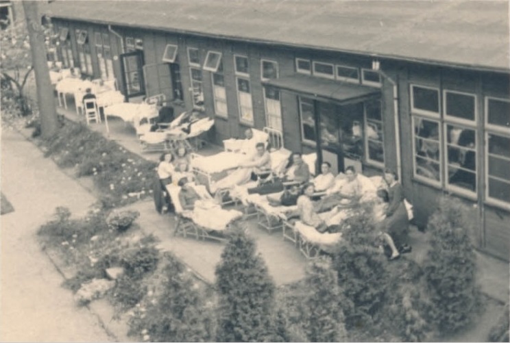 Veenstraat 72 Noodziekenhuis Twente. Patïenten liggen op bed buiten de T.B.C.-barak. 1944.jpg