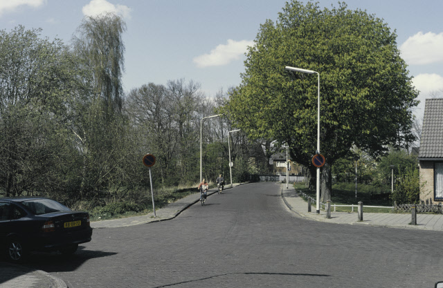 Oostveenweg Straatbeeld gezien vanaf de kruising met Lage Bothofstraat in noordelijke richting met de brug over spoorlijn Enschede-Gronau 1-5-1977.jpeg