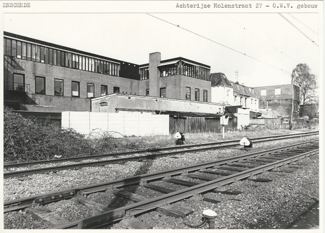Molenstraat Achterzijde van het kantoor van Openbare Werken en Volkshuisvesting. Op de voorgrond de spoorlijn Enschede-Gronau 2-4-1980.jpeg