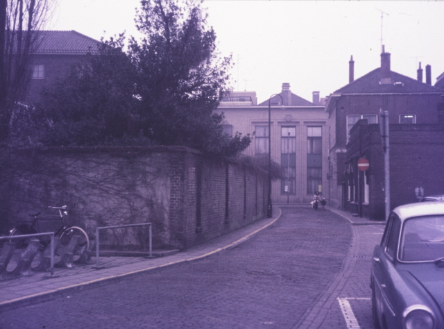 Hofstraat 3 In zuidwestelijke richting met links muur om de stadhuistuin en midden Twentsche Schouwburg aan de Langestraat. 1-2-1973.jpeg