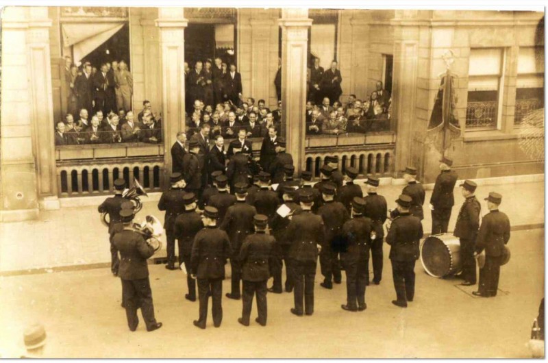 De Koninkl. Ensch. Burger Harmonie brengt een serenade aan de Groote Sociëteit, Langestraat. We zien het korps van achteren en de ontvangers, op en voor het terras van de soos, van voren. Datering 1935.JPG