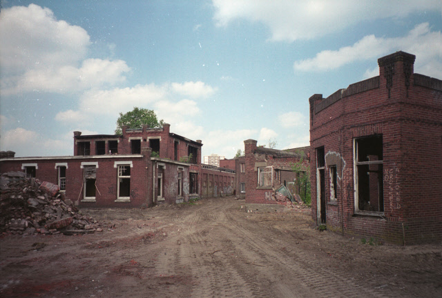 Roomweg 103 hoek Stroinksbleekweg Voorbereidende fase renovatie gebouwen van textielfabriek I.I. Rozendaal na de vuurwerkramp gezien vanaf de Roomweg met rechts het portiers gebouw en links het kantoorgebouw. juni 2001.jpeg