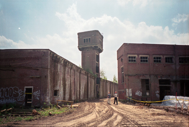 Roomweg 103 hoek Stroinksbleekweg Voorbereidende fase van de renovatie gebouwen van textielfabriek I.I. Rozendaal na de vuurwerkramp gezien in zuidelijke richting met watertoren langs hoofdstraat. juni 2001.jpeg