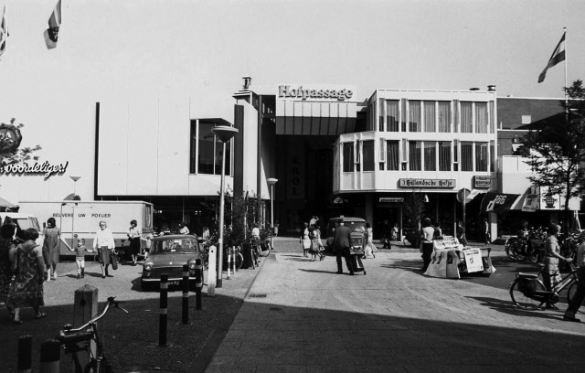 H.J. van Heekplein tijdens warenmarkt met links C&A en ingang van winkelcentrum Hofpassage cafe 't Holandsche Hofje.jpeg
