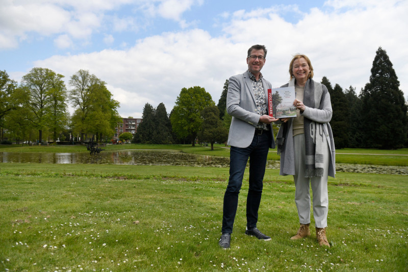 Volkspark. Gerrit van Oosterom met het boek dat hij schreef over het Volkspark. Naast hem Quirine van Heek. Sinds de stichting in 1874 zat er steeds een lid van de familie Van Heek in de beheerscommissie van het park..jpg