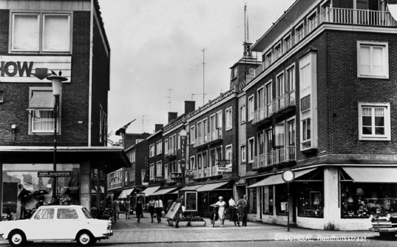 Raadhuisstraat 23 gezien vanaf het H.J. van Heekplein. Zichtbaar is o.a. drogisterij De Vijzel en winkel Haarink.jpeg