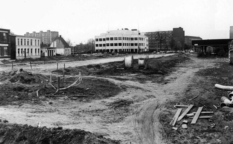 Veenstraat 7-25 vanaf Brinkstraat. Braakliggend terrein voor de aanleg van de Oldenzaalsestraat, met het Oaldste Hoes, Drukkerij Roelofs en NMB Bank. okt. 1979.jpeg